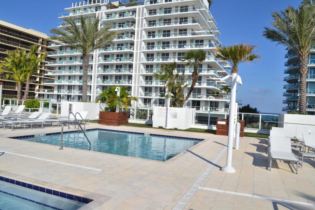 迈阿密海滩冲浪道西海滩格兰德酒店的一座游泳池,其背后是一座大型公寓楼