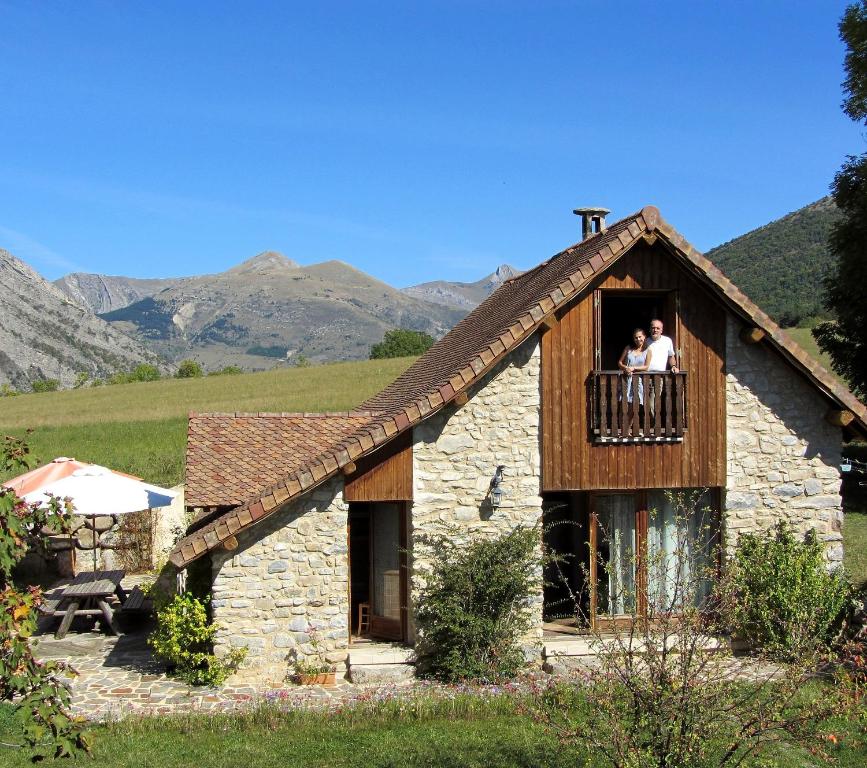 La Roche-des-ArnaudsGite Le Clos de Lumière的一对夫妇站在房子的阳台上