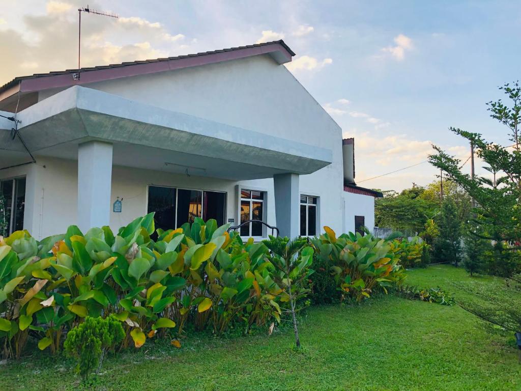 太平Homestay Lestary near Taiping Fast WIFI Netflix的前面有绿色灌木的白色房子