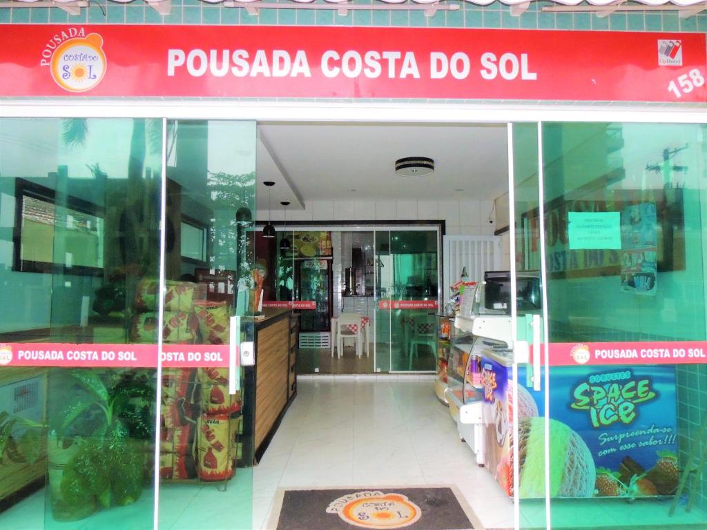 大普拉亚Pousada Costa Do Sol - By UP Hotel的前面有红色标志的商店