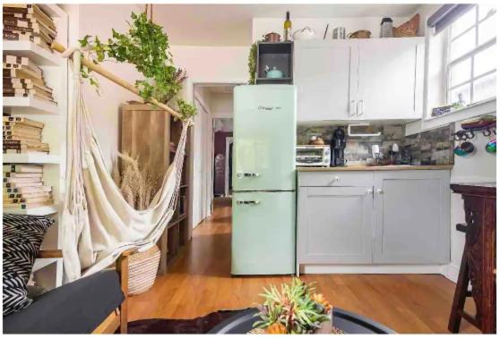 迈阿密The Cozy Villa-private parking的厨房配有白色橱柜和绿色冰箱。