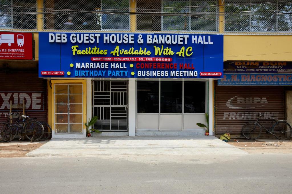 加尔各答deb Guest House And Banquet hall的前面有标志的建筑