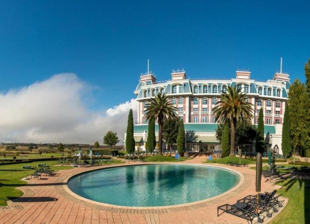 塞昆达雅园沃尔蒙特酒店的一座大型建筑,前面设有一个游泳池