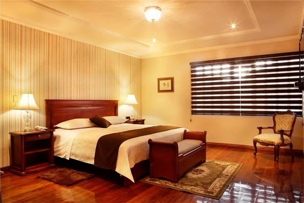 昆卡艾米利亚别墅住宿加早餐旅馆的卧室配有床、椅子和窗户。