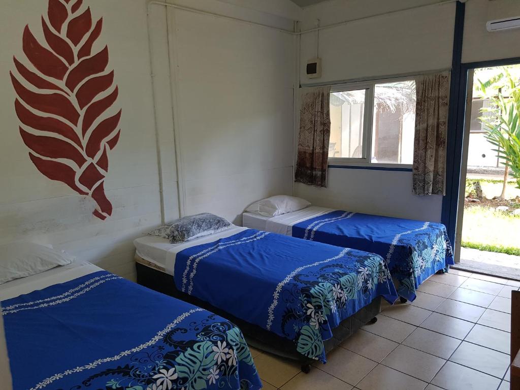 阿皮亚Olivias Accommodation的客房设有两张床和窗户。