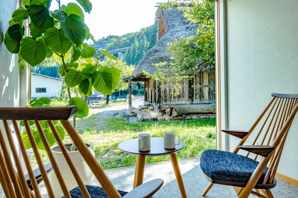 白川村CURIO Shirakawago的一间设有两把椅子、一张桌子和一个窗户的房间
