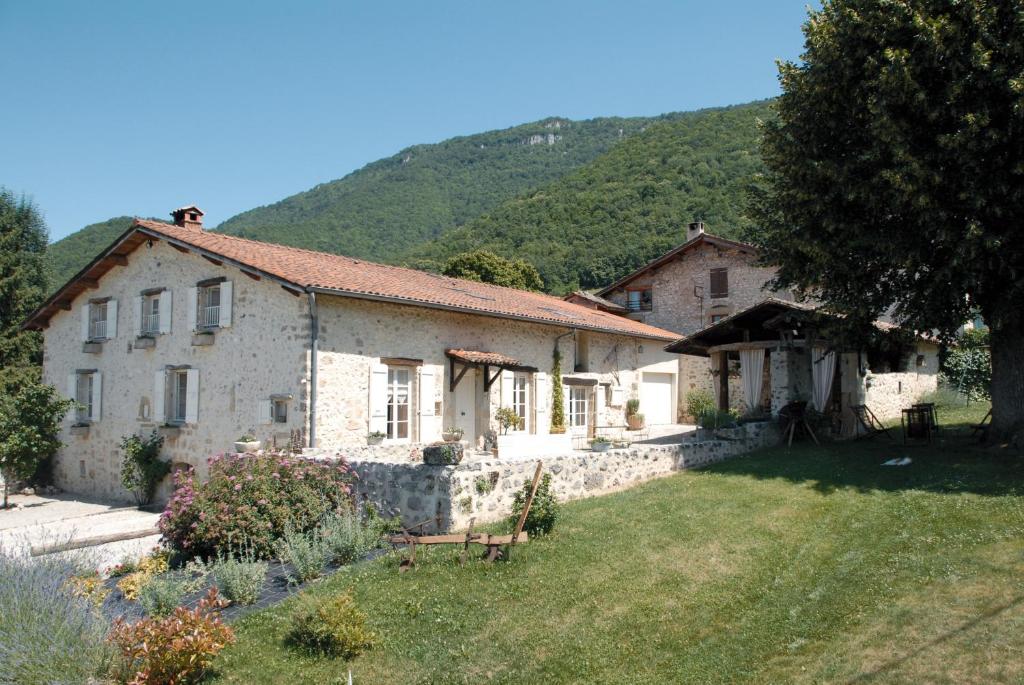 鲁瓦扬地区圣让艾斯塔帕德图勒隆住宿加早餐旅馆的一座大石头房子,后面有一座小山