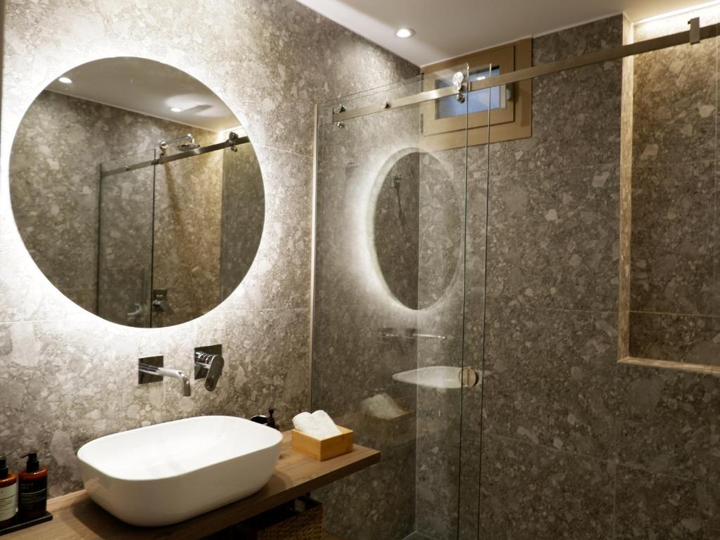 AchílleionKaiser Luxury Suites的浴室配有盥洗盆和带镜子的淋浴
