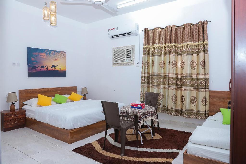 尼兹瓦Nima guest house的一间卧室配有一张床、一张桌子和一张沙发