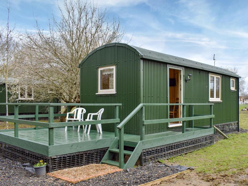 YaldingShepherds Hut 1 At Laddingford - Uk32531的绿色的小房子,设有门廊和甲板