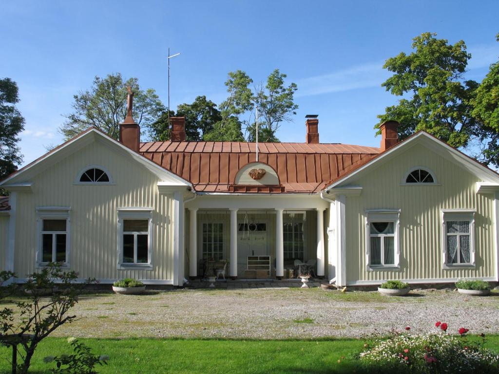 LohjaVohloisten Kartano的一座大型白色房屋,设有红色屋顶
