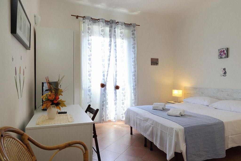 佛罗伦萨米娅宫旅馆的一间卧室配有一张床、一张书桌和一个窗户。