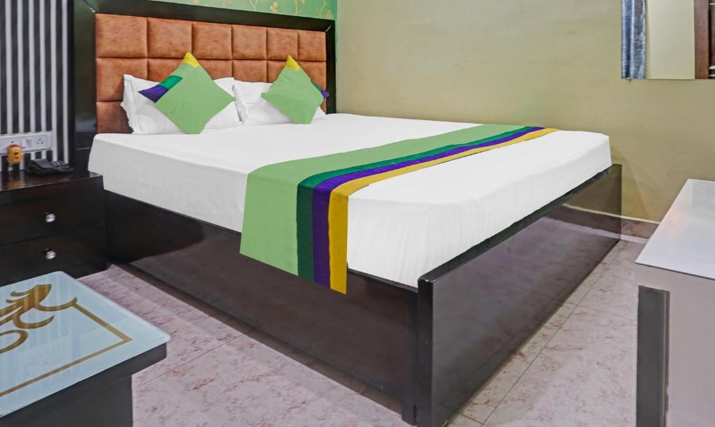 巴特那Hotel Prem Residency的一间卧室配有一张大床和色彩缤纷的毯子