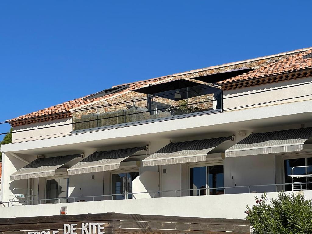 耶尔Résidence San Paolisa的公寓大楼设有阳台,享有蓝色的天空