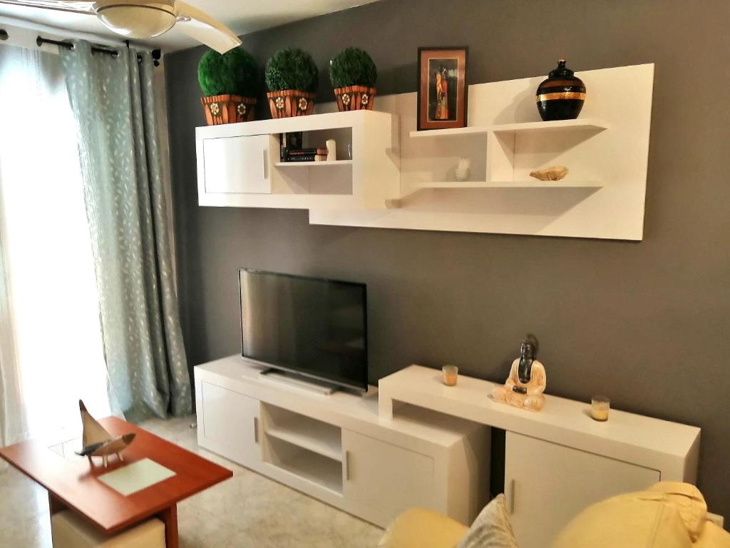 托里代巴拉Precioso apartamento de lujo的客厅配有白色架子和平板电视