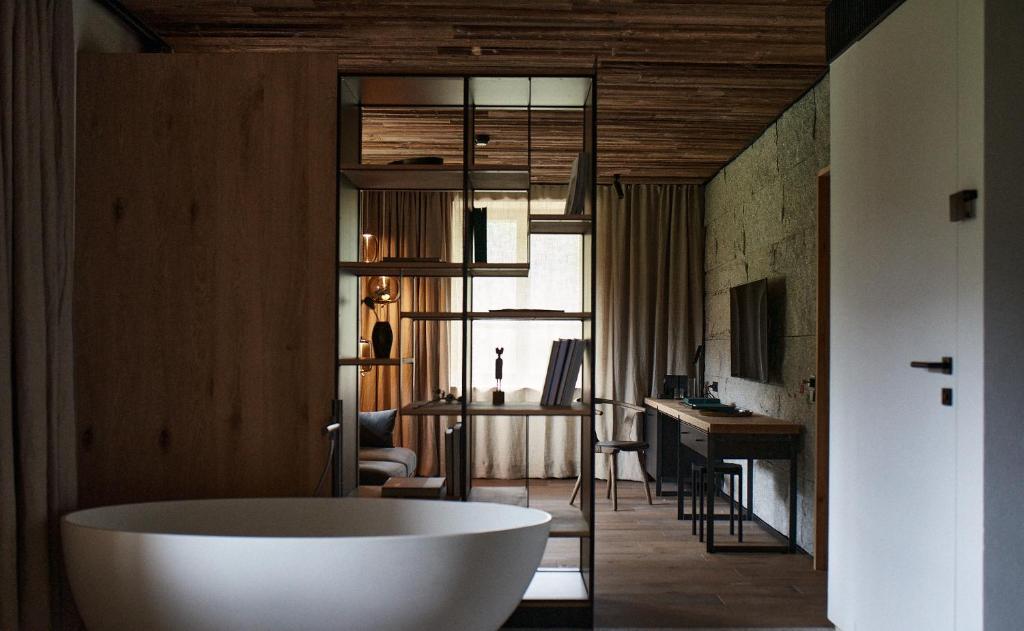 扎科帕内EnHotel的一间带浴缸的浴室,位于一间配备有书桌的客房