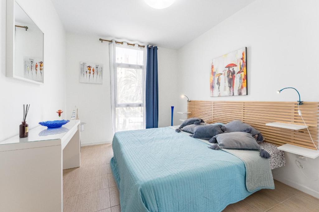 阿罗纳Central Los Americos Apartment的一间卧室配有蓝色的床和枕头