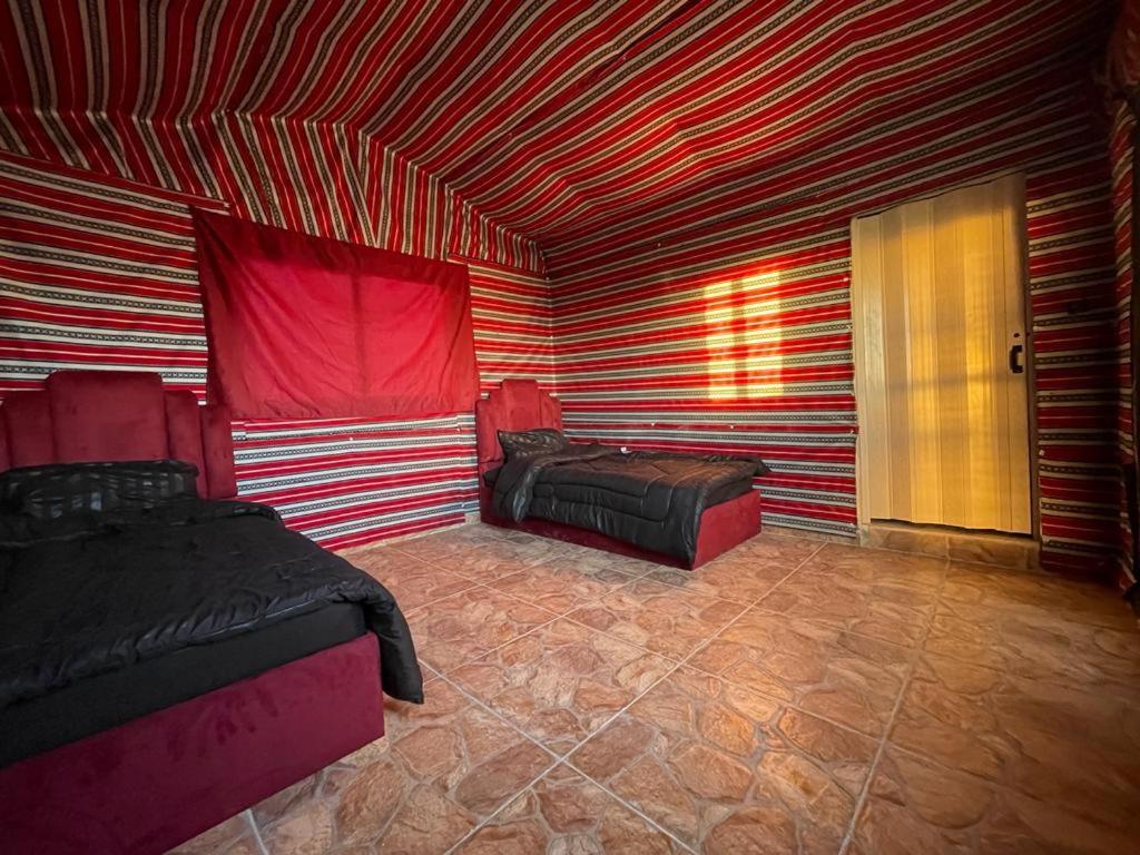 达纳Dana Sunset Eco Camp的客房设有两张床和红色及白色条纹天花板