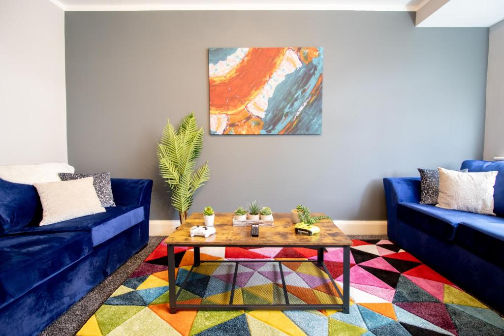 布里斯托Stunning House Free Parking Garden WiFi的客厅配有蓝色的沙发和茶几