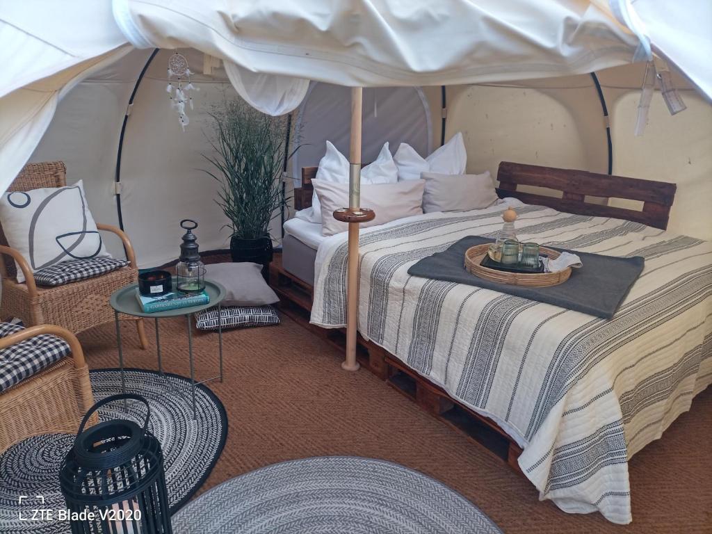 巴姆施泰特Glamping Altes Pastorat的帐篷内一间卧室,配有一张床