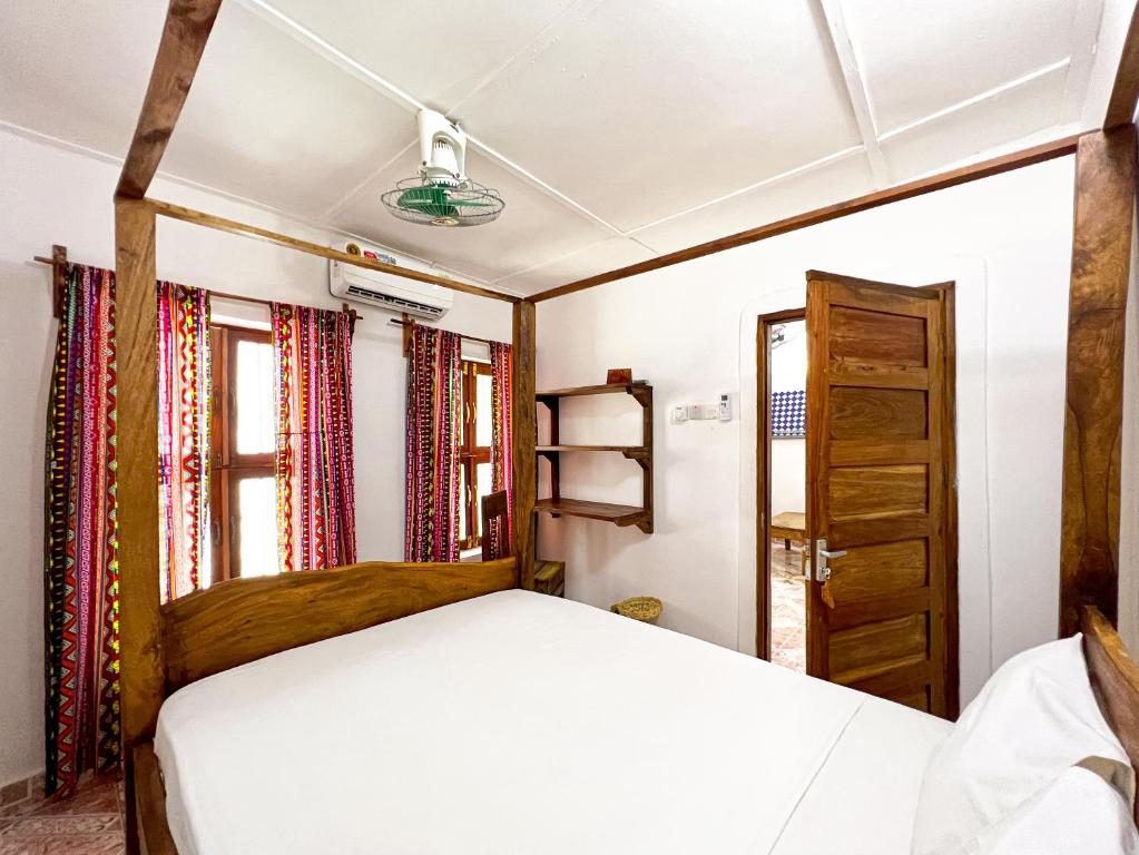 桑给巴尔Shoki Shoki Hostel的一间卧室设有一张床和一个窗口