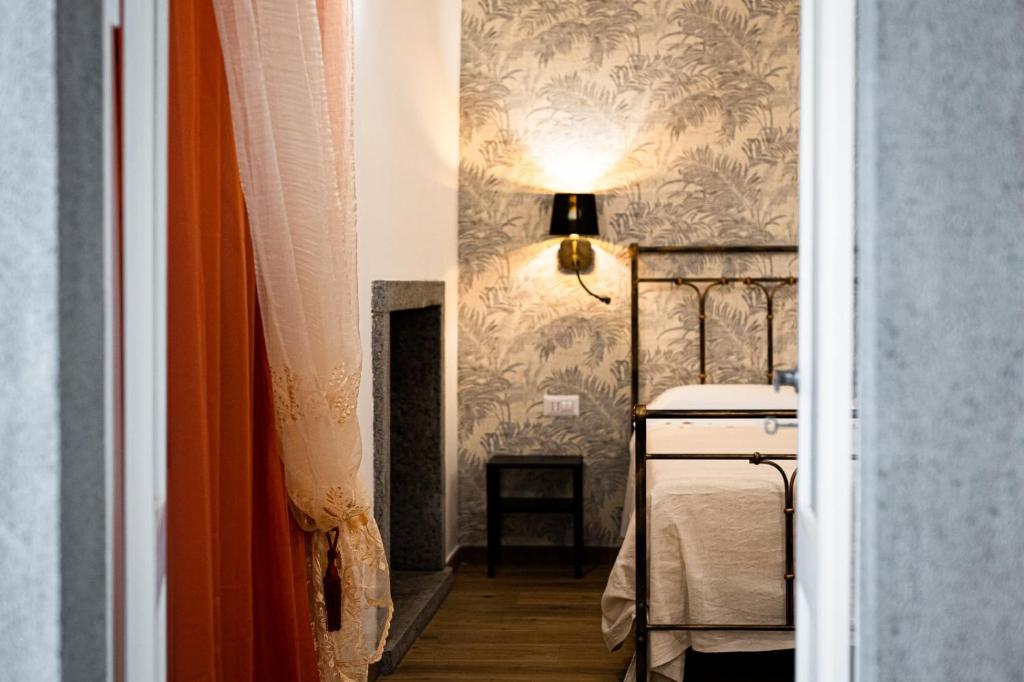 巴尼奥雷焦La Dimora del Principe的一间卧室配有一张床,墙上配有一盏灯