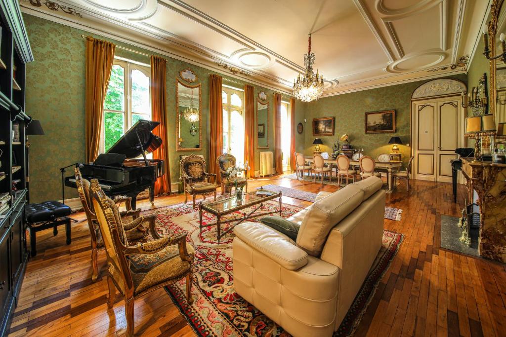 Saint-SulpiceLe Manoir du Thouron的带沙发和钢琴的客厅