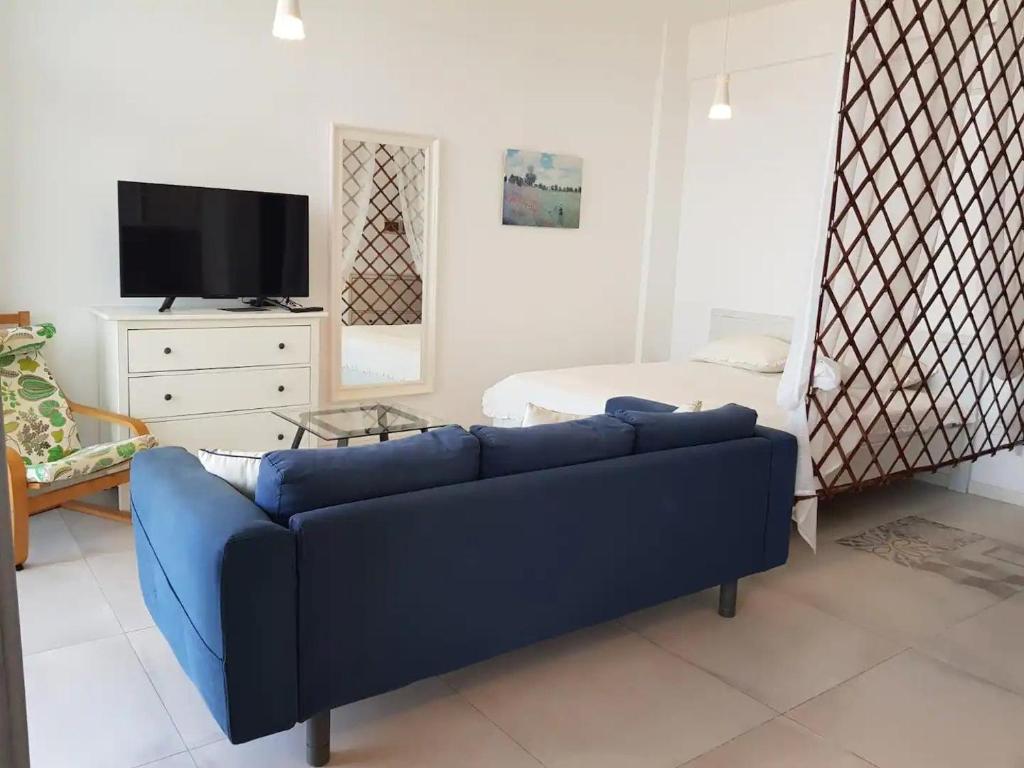 西哈努克Seaview Modern Studio的客厅配有蓝色的沙发和床。