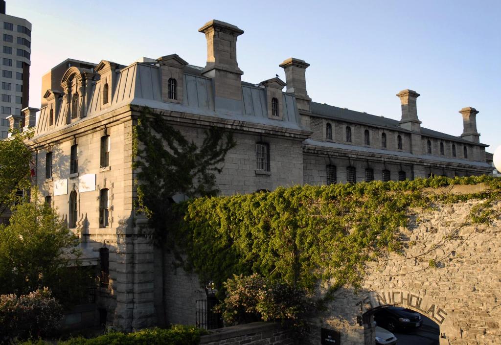 渥太华Saintlo Ottawa Jail Hostel的墙上有常春藤的古老石头建筑