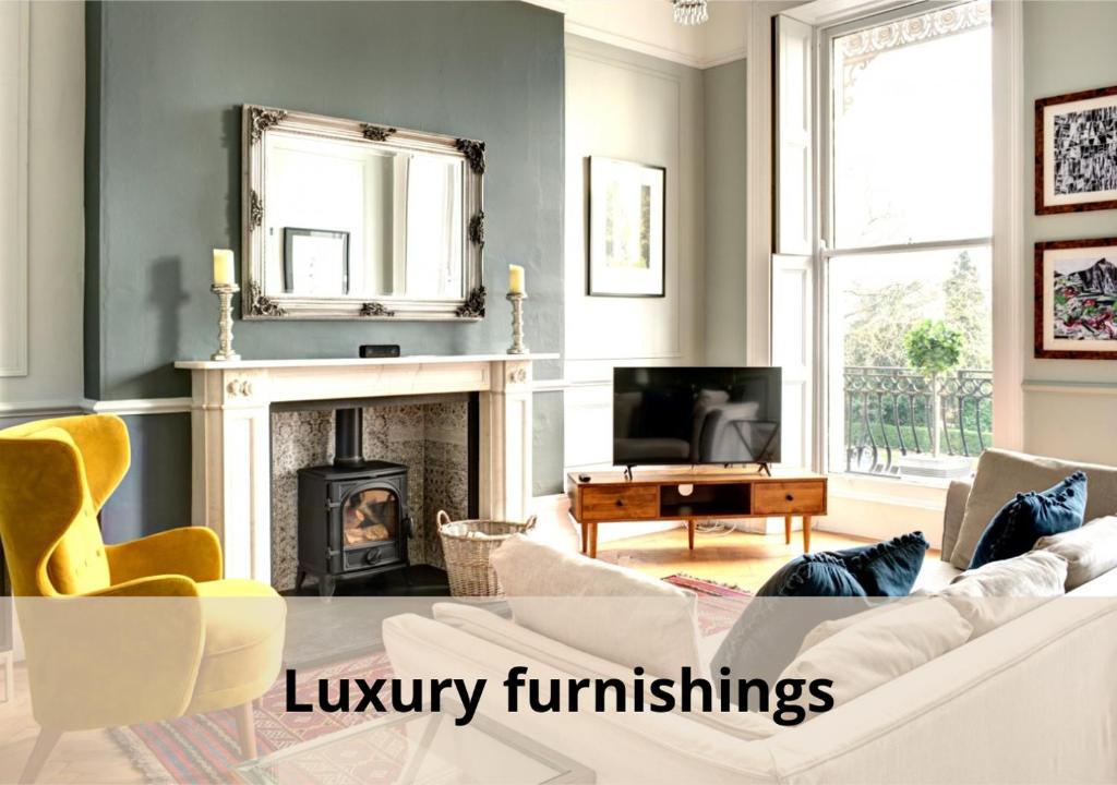 切尔滕纳姆16 Lansdown Flat 3 - By Luxury Apartments的客厅配有白色沙发和壁炉