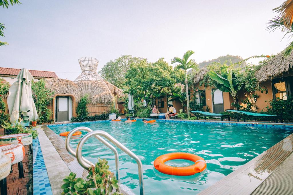 宁平Tam Coc Sky Bungalow的一座带橙色木筏的度假村游泳池