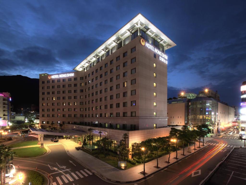 釜山侬新酒店的一座高大的建筑,晚上有街道