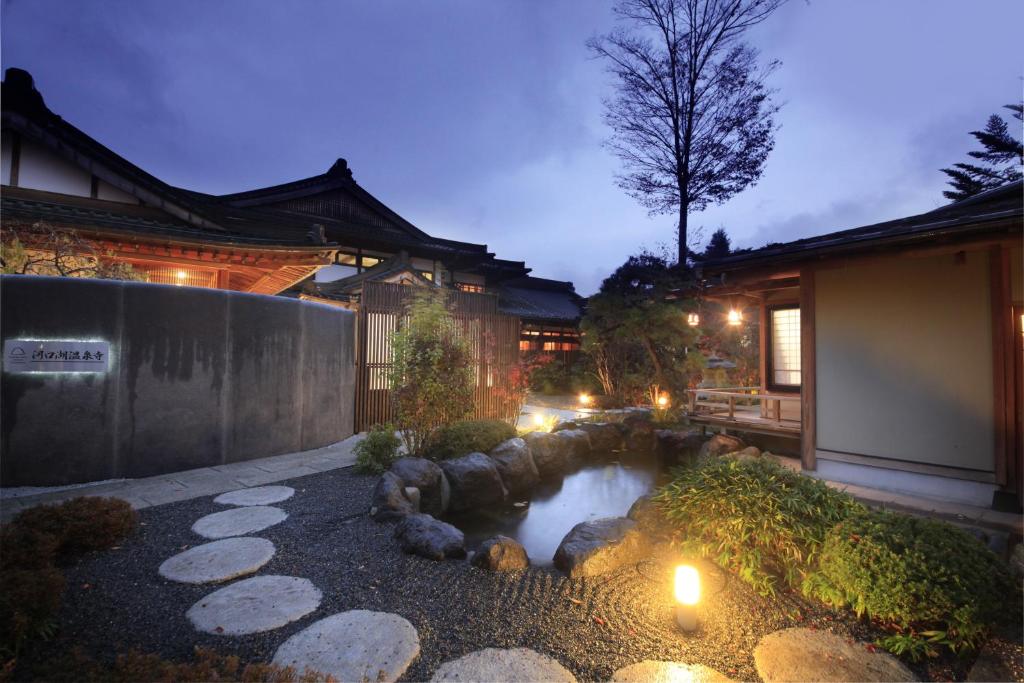 富士河口湖富士温泉寺梦殿日式旅馆的房屋前带池塘的花园