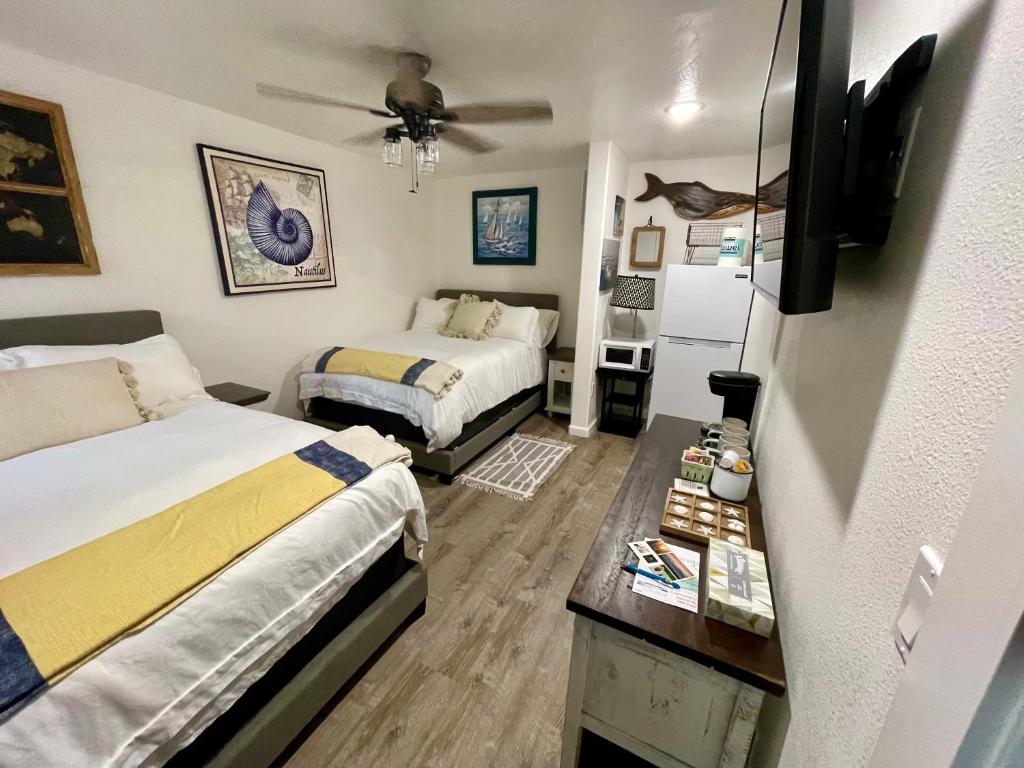 荷马Seafarer Suites的一间卧室配有两张床和吊扇