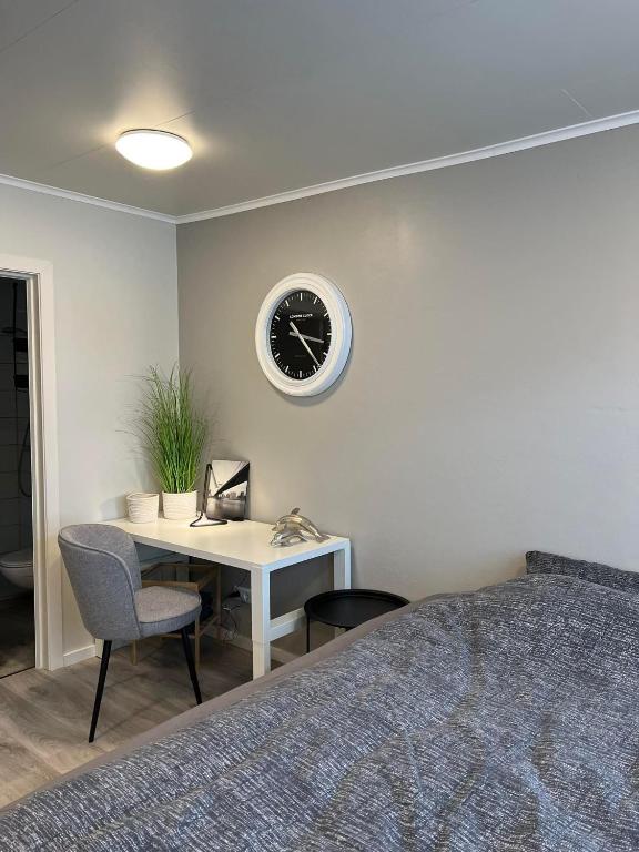 雷克雅未克Helena's studio, Reykjavík 104的一间卧室配有一张桌子和墙上的时钟
