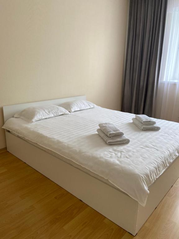 阿斯塔纳Апартаменты в центре города的一张白色的床,上面有两条毛巾