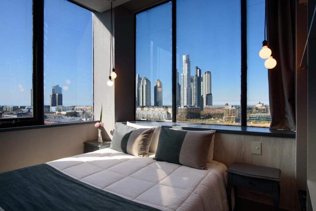 布宜诺斯艾利斯Believe Madero Hotel的卧室设有大窗户,享有城市美景。