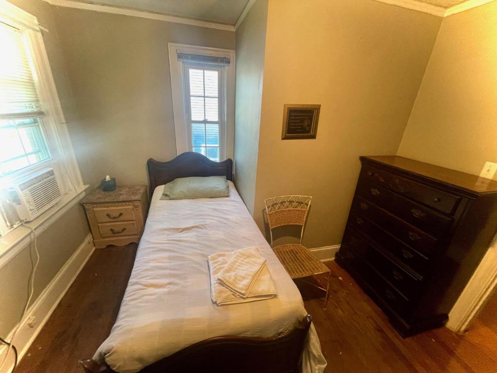 落基山Best Rooming Houses in Rocky Mount NC.的一间小卧室,配有一张床和一个梳妆台