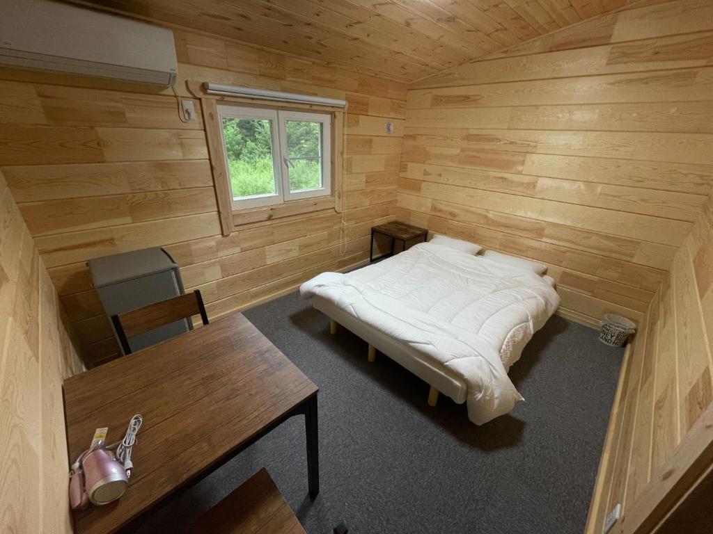高岛市Biwako Hills Resort - Vacation STAY 47924v的木制客房内配有一张床和一张书桌的房间