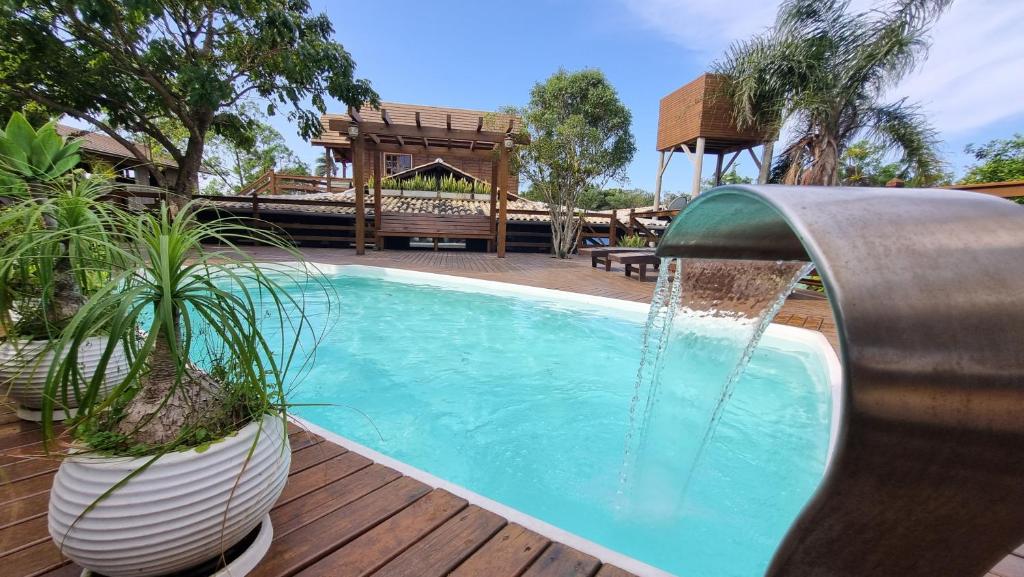 普腊亚罗萨Arte da Tribo Hostel & Camping的一个带喷泉的游泳池