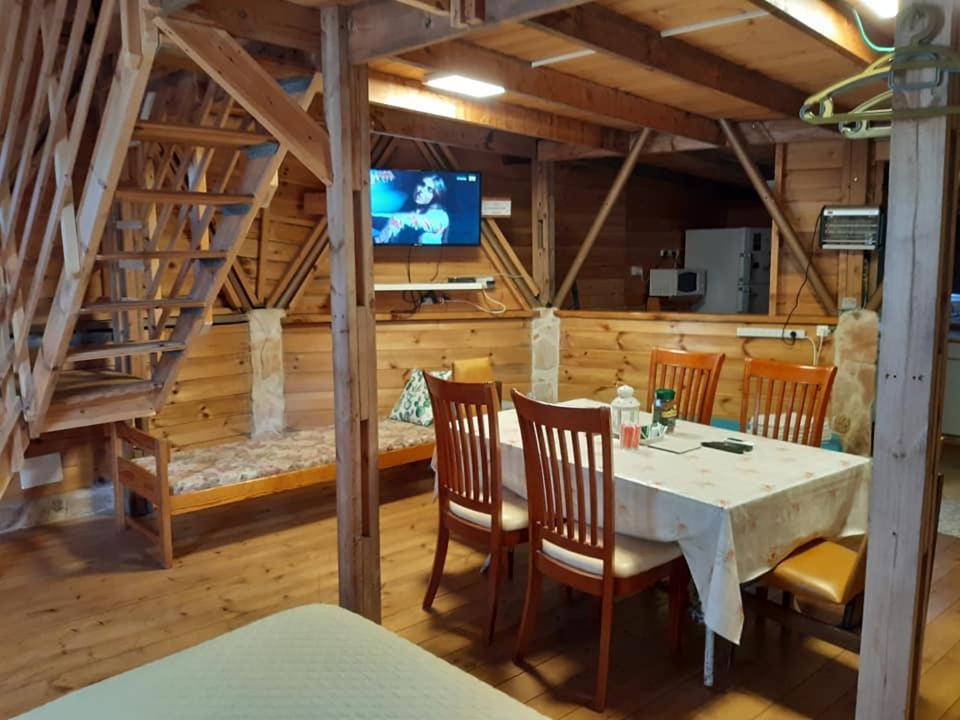 Manotבקתת עץ בחורש במנות - דום גיאודזי - Wooden cabin in Manot的一间带桌椅的用餐室