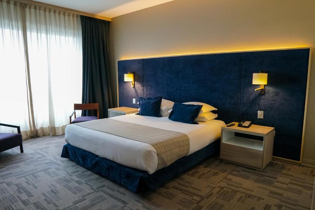 利纳雷斯Hotel Parada Linares的酒店客房,设有一张蓝色墙壁的大床