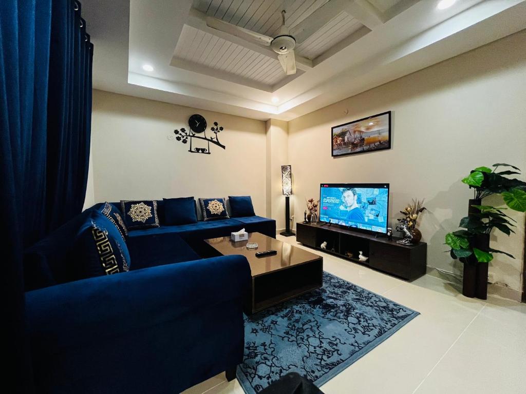 伊斯兰堡Entire 1 BR Apartment: Netflix, Youtube.的客厅配有蓝色的沙发和电视