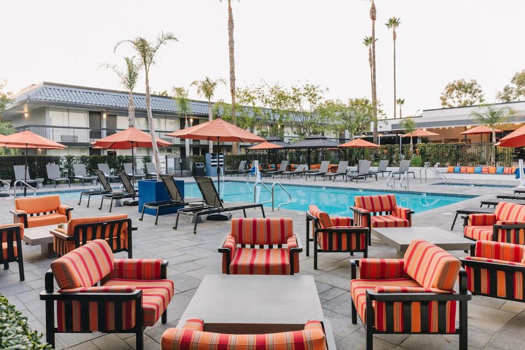 千橡市棕榈树花园酒店的游泳池旁带桌椅的游泳池