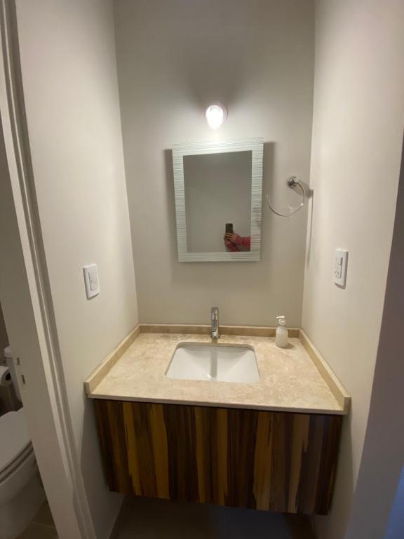 卢汉德库约Ocean Apartments的一间带水槽和镜子的浴室