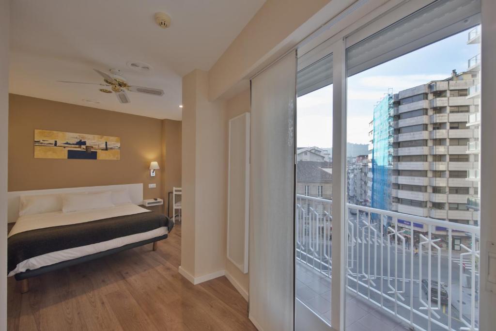 奥伦塞米尼奥酒店的一间卧室设有一张床和一个阳台