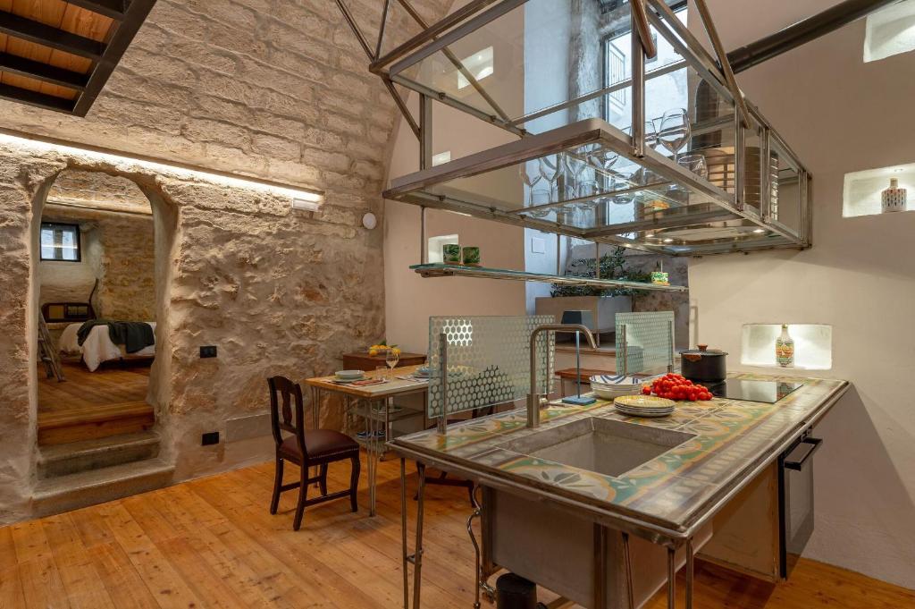 奥斯图尼Il Quinto Elemento - Residence Of Charme的一间厨房和带石墙的用餐室