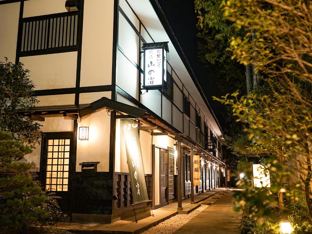 箱根箱根温泉 汤宿 山之省的一座建筑,晚上在它旁边有一个钟