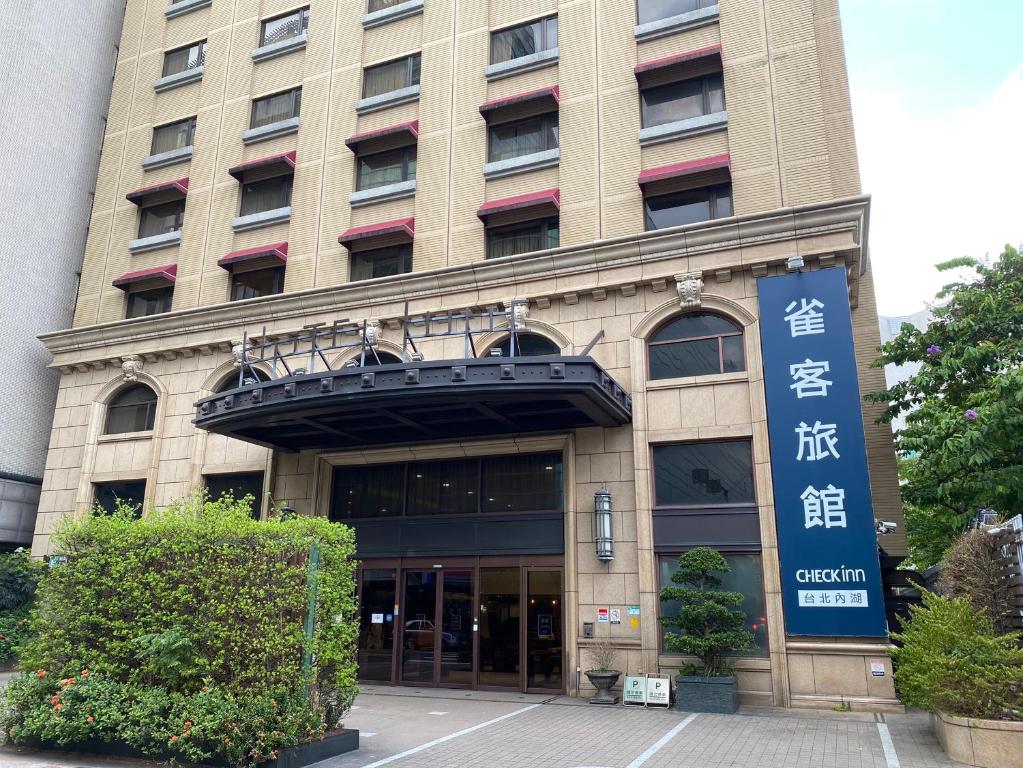 台北CHECK inn Taipei Neihu的前面有标志的建筑