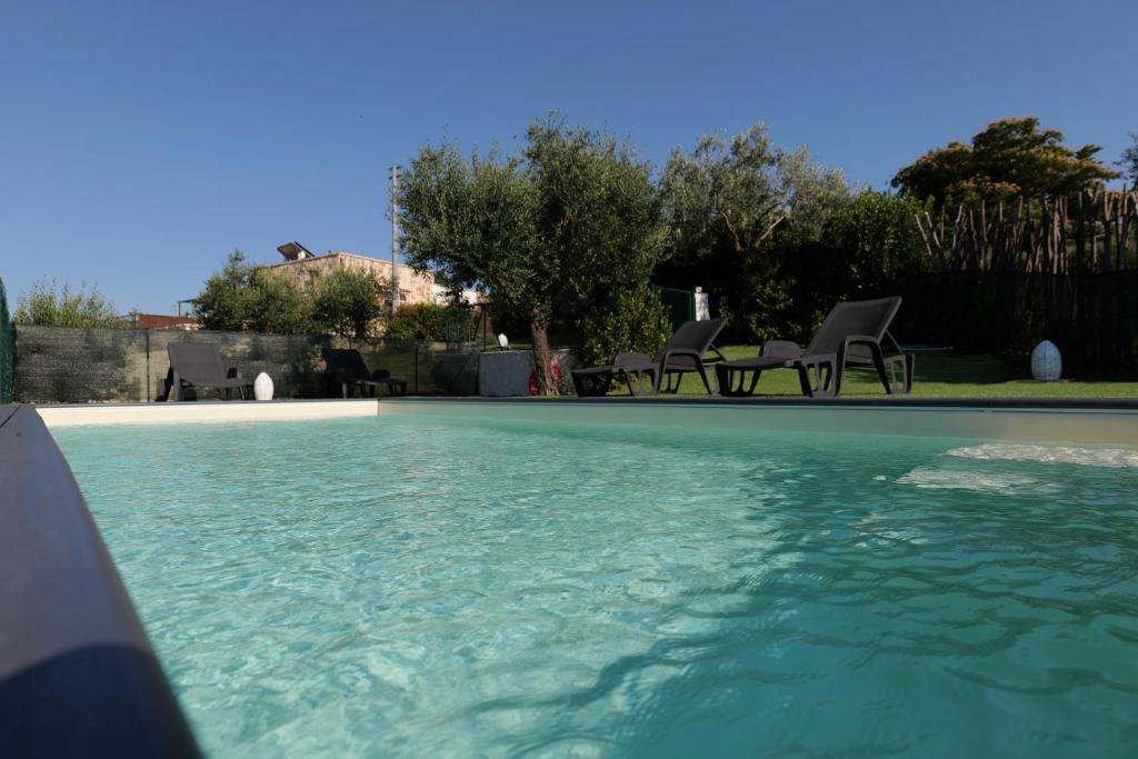 马丁纳弗兰卡Il Borgo Delle Querce Villa Fichi Piscina privata的游泳池,带椅子和水
